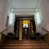 ...che si apre su una scala di ingresso illuminata da due lampade verticali...